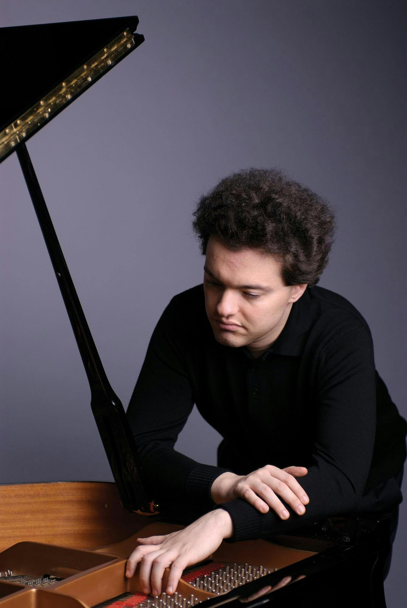Photo of Evgeny Kissin looking into an open grand piano