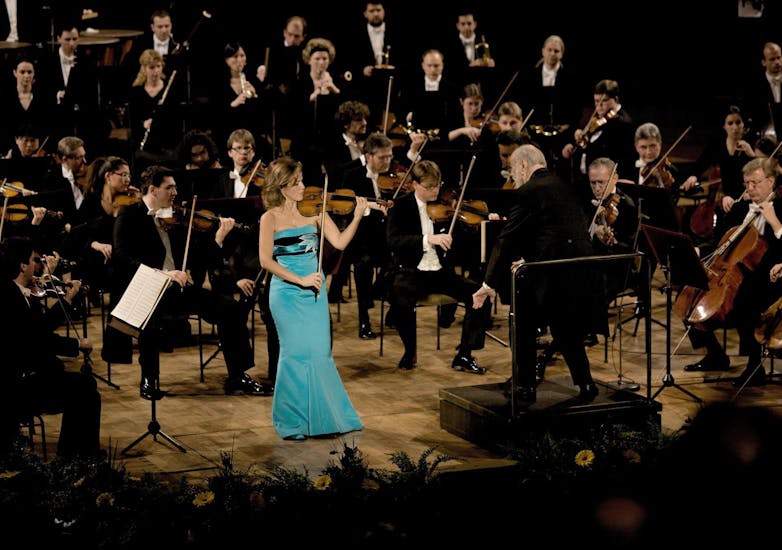 Anne-Sophie Mutter performs on stage with conductor Kurt Masur and orchestra
