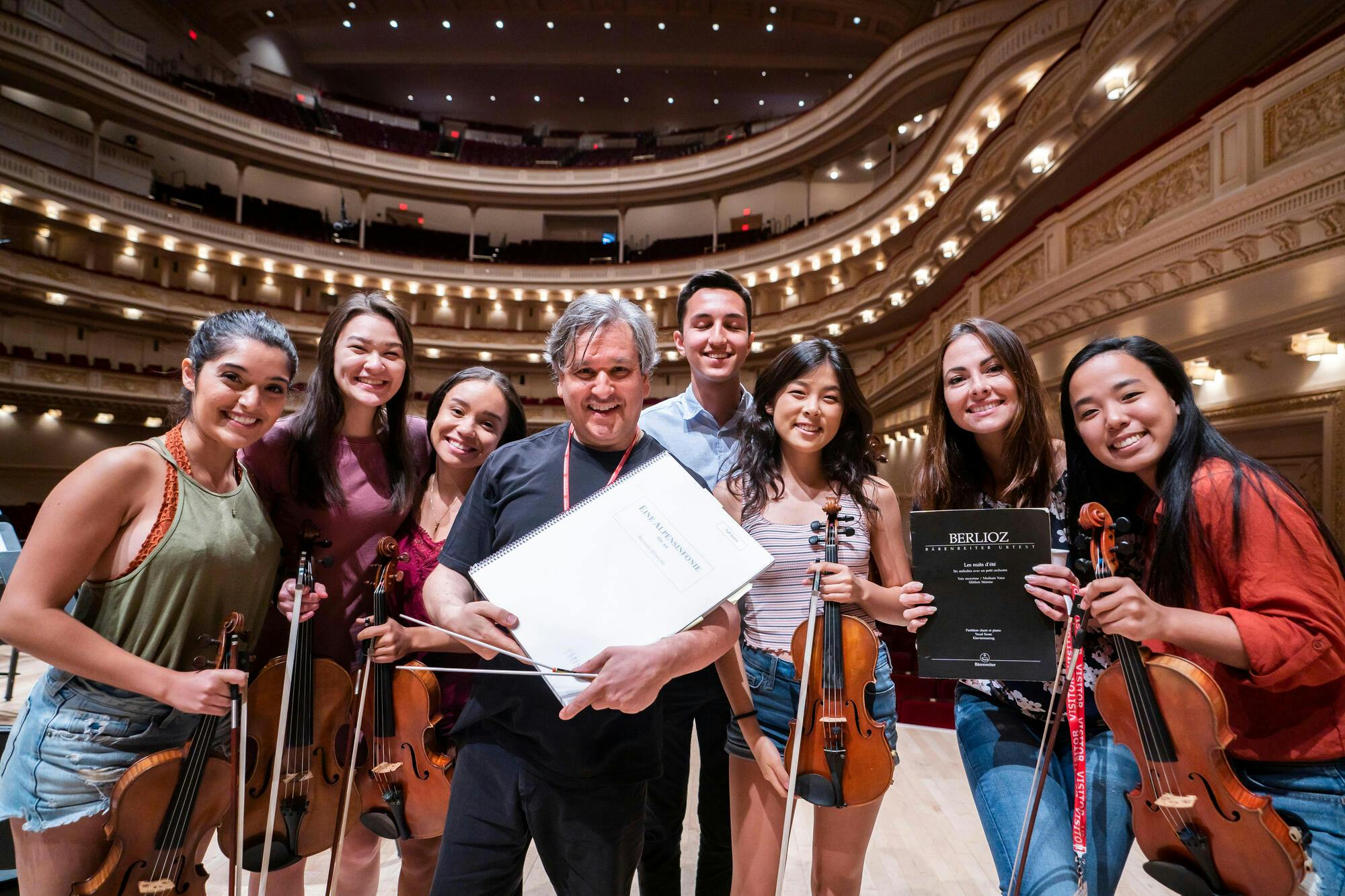 Nikki Naghavi (left) at Carnegie Hall with fellow NYO-USA members, mezzo-soprano Isabel Leonard (second from right), and conductor Antonio Pappano (center), 2019