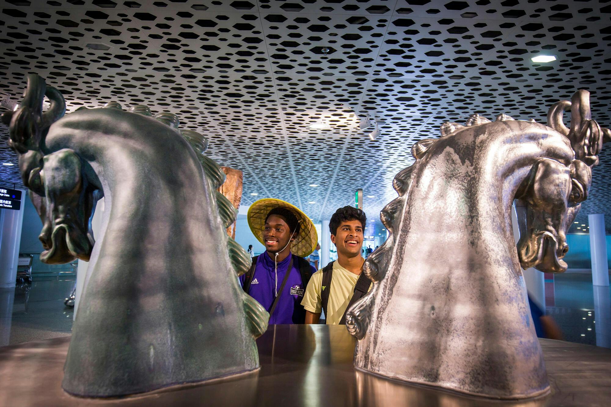 Two NYO members observing two statues in a museum