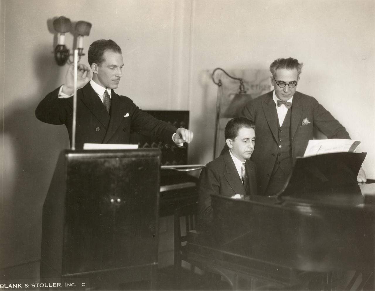 Leon Theremin (inventor of the ether wave instrument), Josef Schillinger (composer at the piano), and Nikolai Sokoloff (conductor of The Cleveland Orchestra), 1929