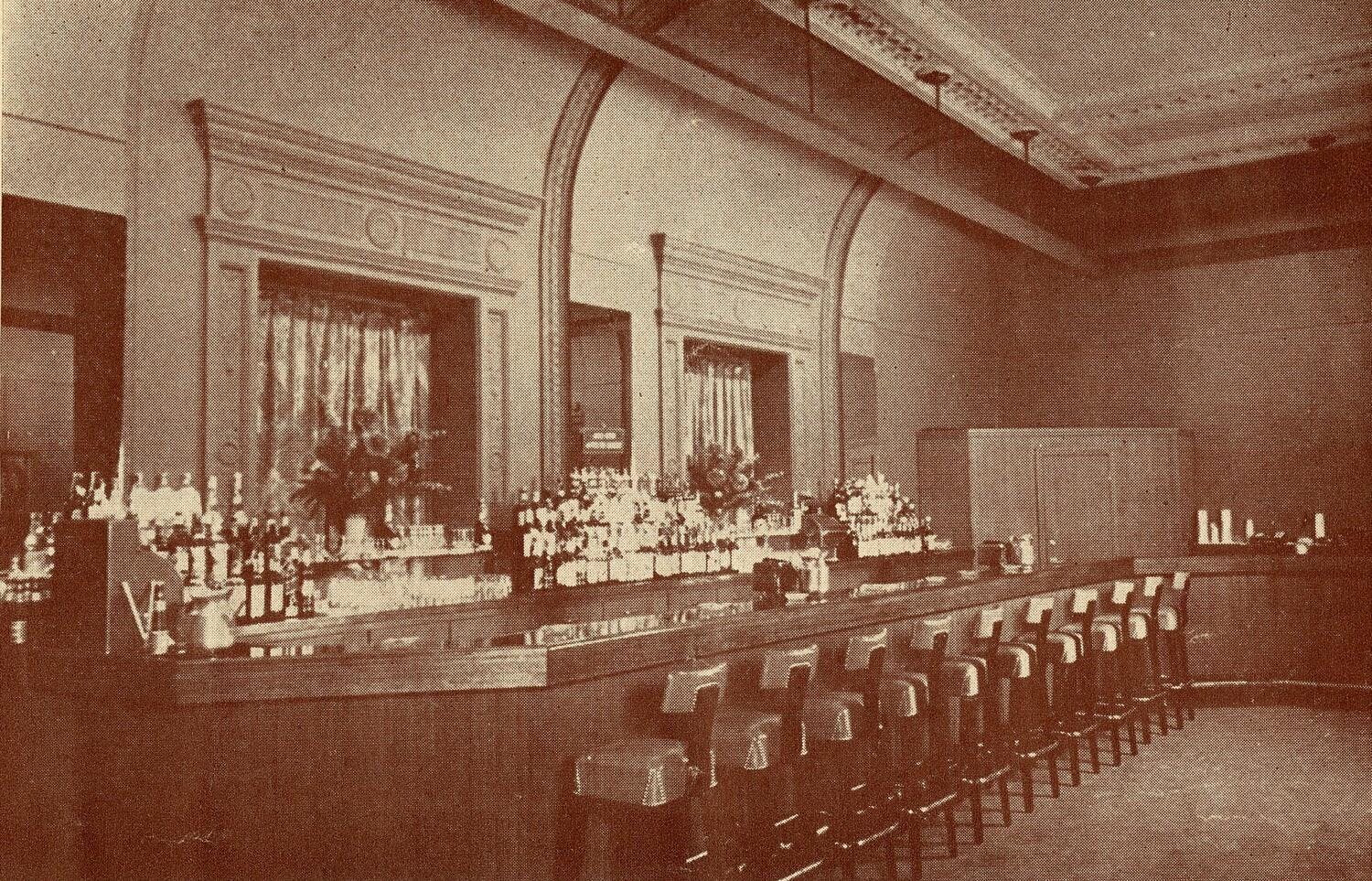 The Carnegie Hall Gallery Bar with a wooden bar and many high-top chairs 