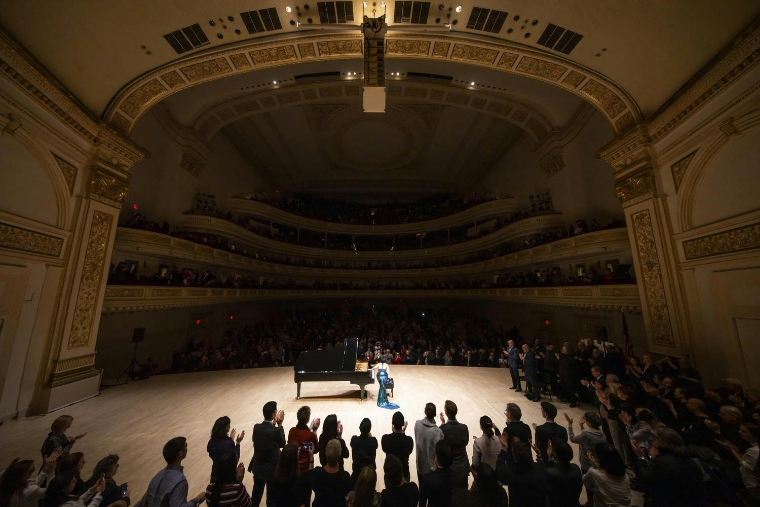 Stern Auditorium / Perelman Stage from the back, Yuja Wang taking a bow on stage as the audience applauds 