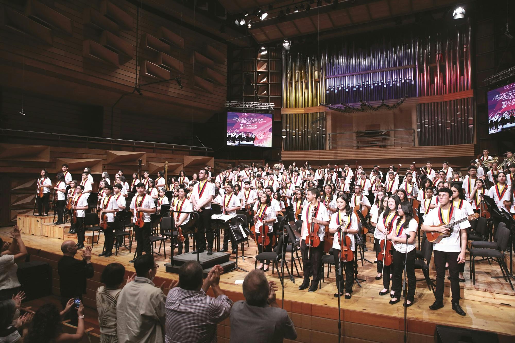 The National Children’s Symphony of Venezuela standing on stage 