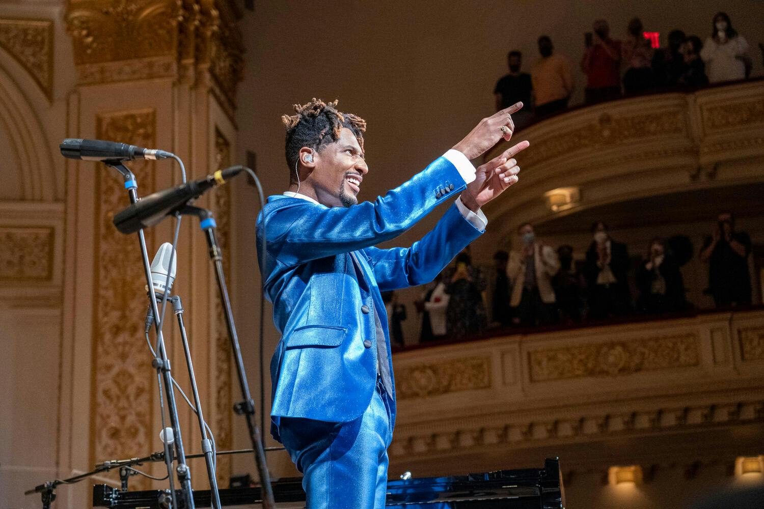Jon Batiste pointing two hands towards the audience.