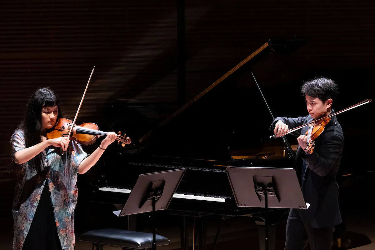 Two violinists from The Juilliard School perform on stage in Zankel Hall.
