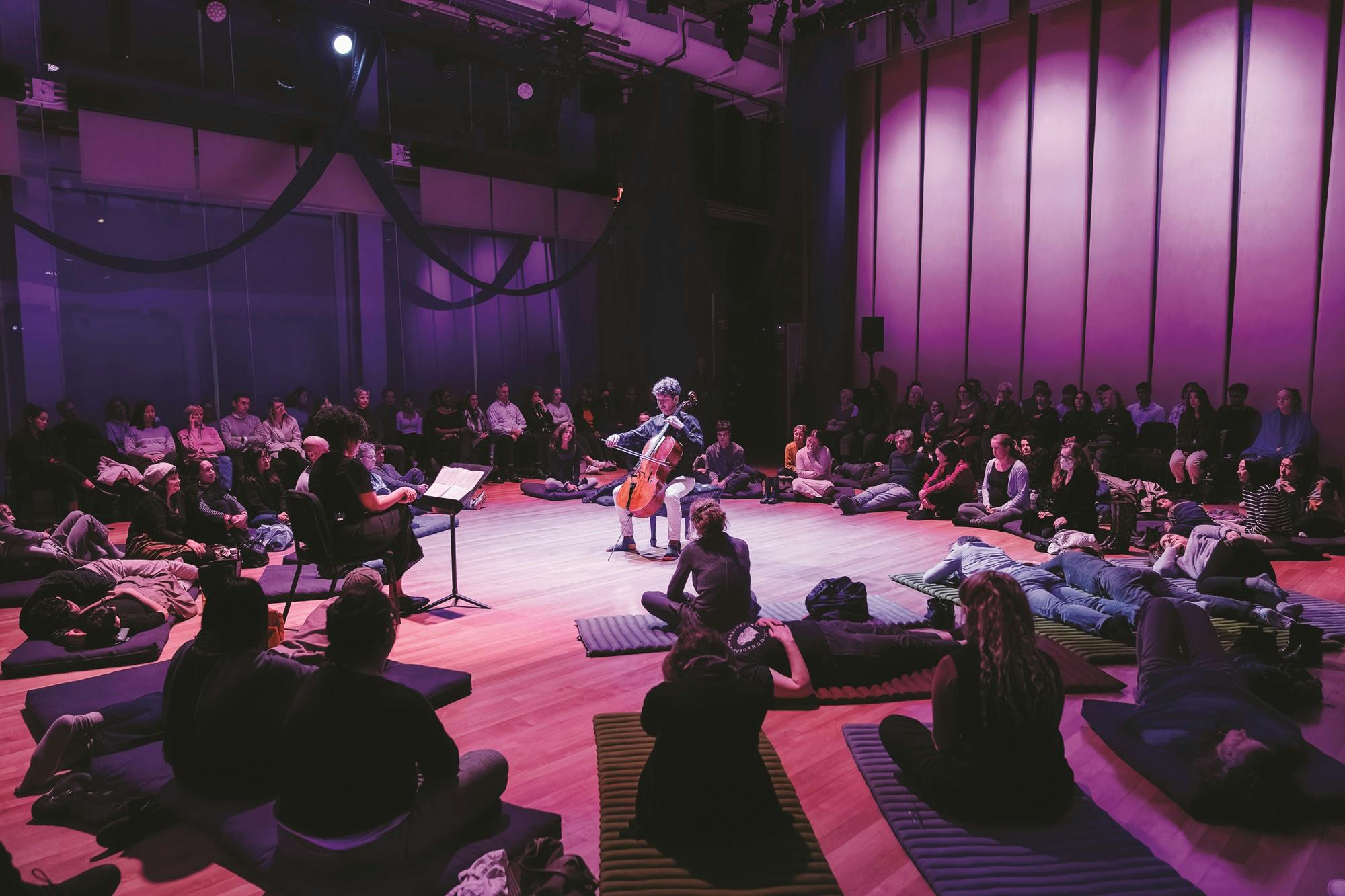 Joshua Roman playing the cello in the center of the Weill Music Room during a Well-Being Concert.