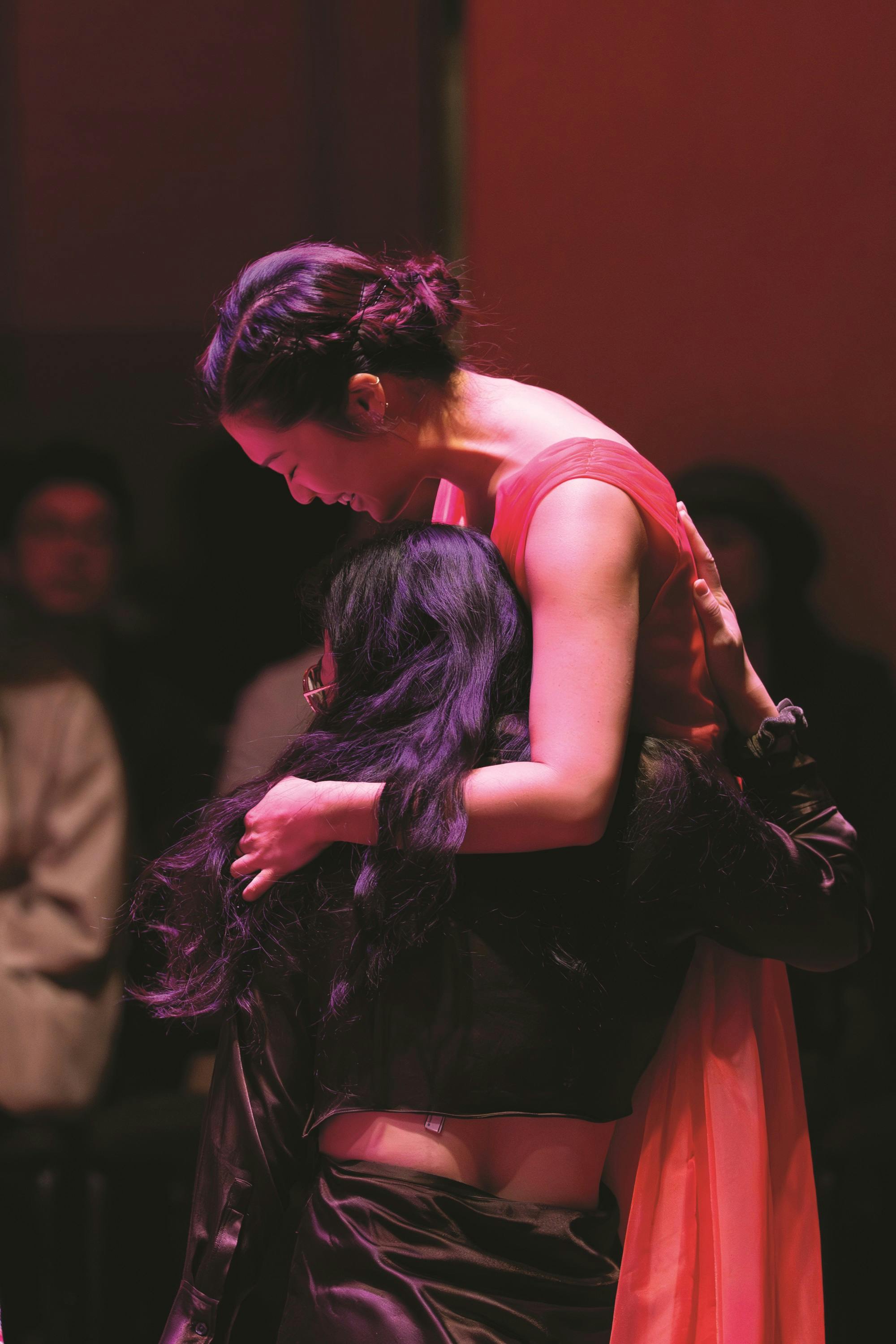 Annie Wu embracing an audience member during a Well-Being Concert.