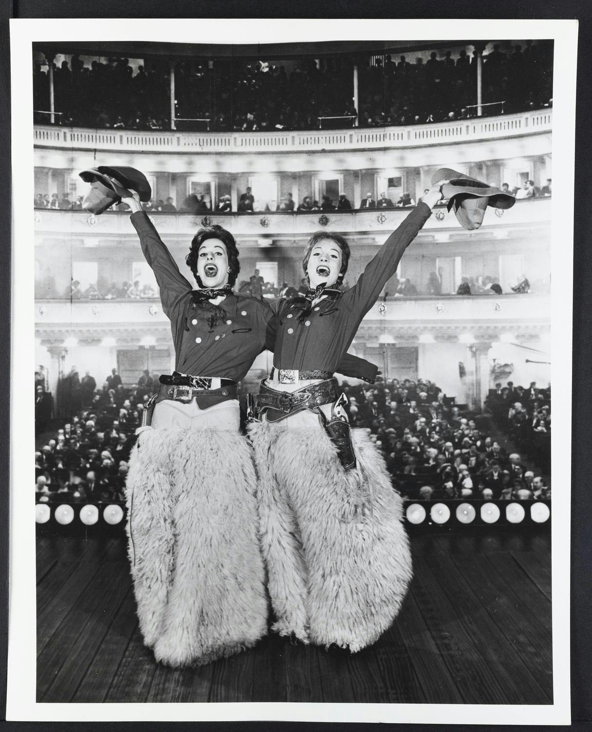 Julie Andrews and Carol Burnett posing on stage with the audience in the background at Carnegie Hall.