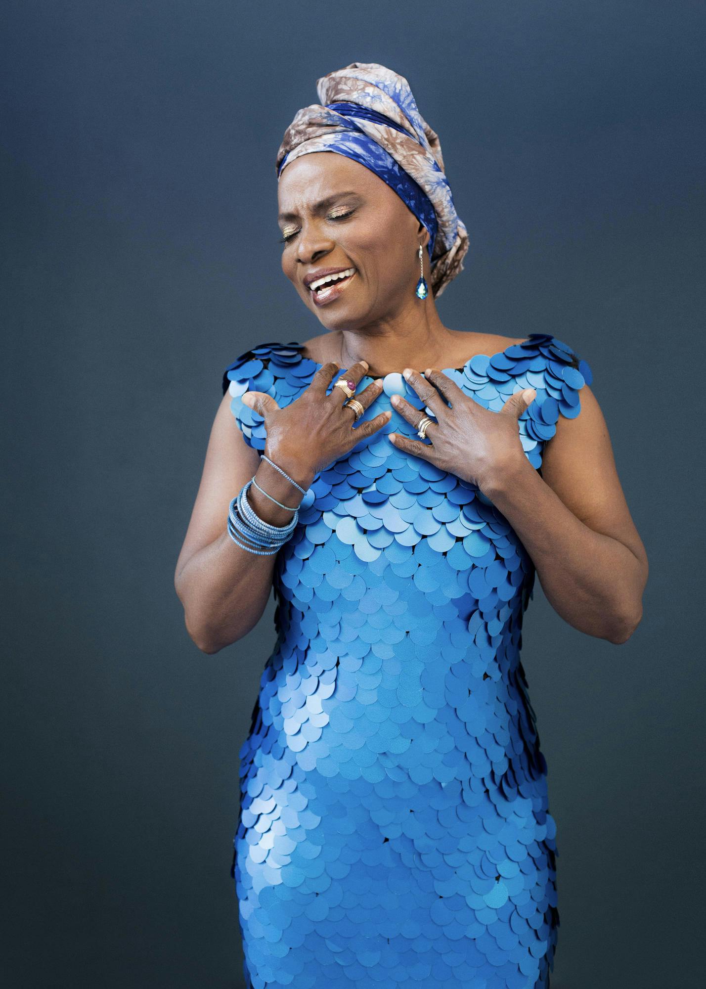 Photo of Angélique Kidjo wearing a blue sequin dress.