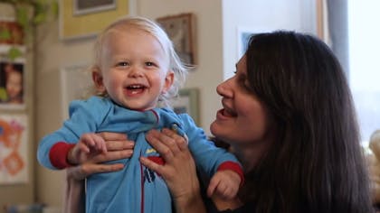 Emily Eagen sings to her smiling young child