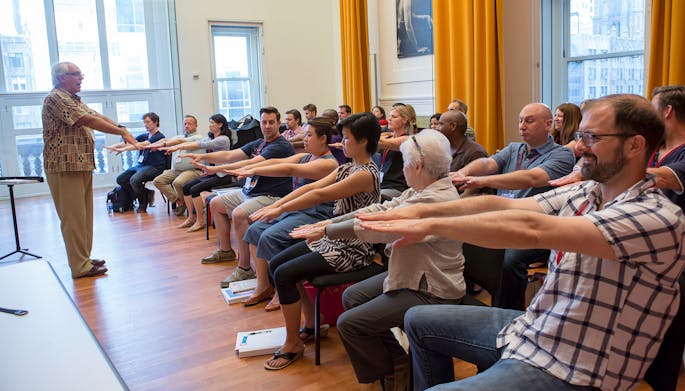 Michael Haithcock leads a group of music educators in an exercise