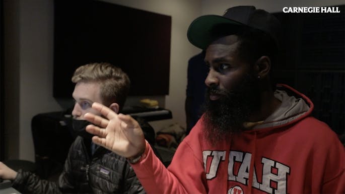 Two men sit at a studio mixing board
