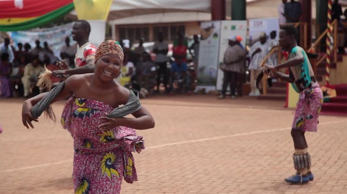 Dancers in colorful purple and yellow outfits