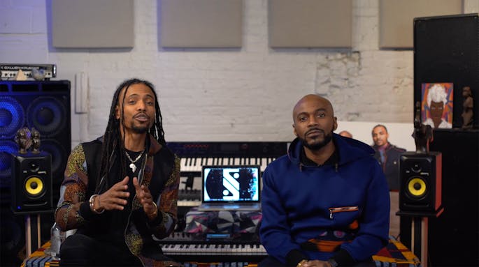 Chen Lo and Asante Amin sit before a bank of keyboards