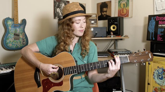 Bridget Barkan plays an acoustic guitar in her studio.