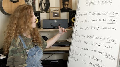 Bridget outlines rhyme patterns in her song on a whiteboard.