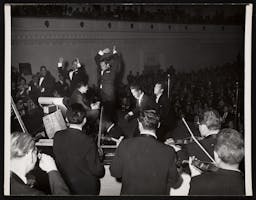 Dean Martin conducting an orchestra at Carnegie Hall.