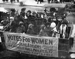 Black-and-white photograph of Jane Addams and others holding a banner advertising a talk on the women’s suffrage movement at Carnegie Hall