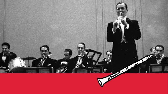 Benny Goodman playing clarinet on stage with his ensemble