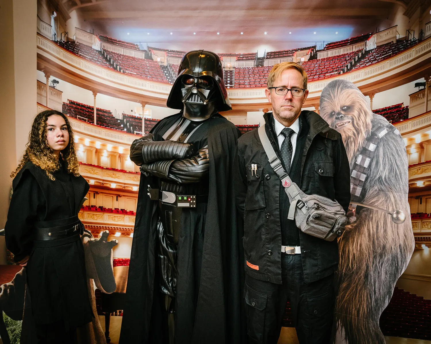 People posing in Star Wars costumes against a backdrop of Carnegie Hall.