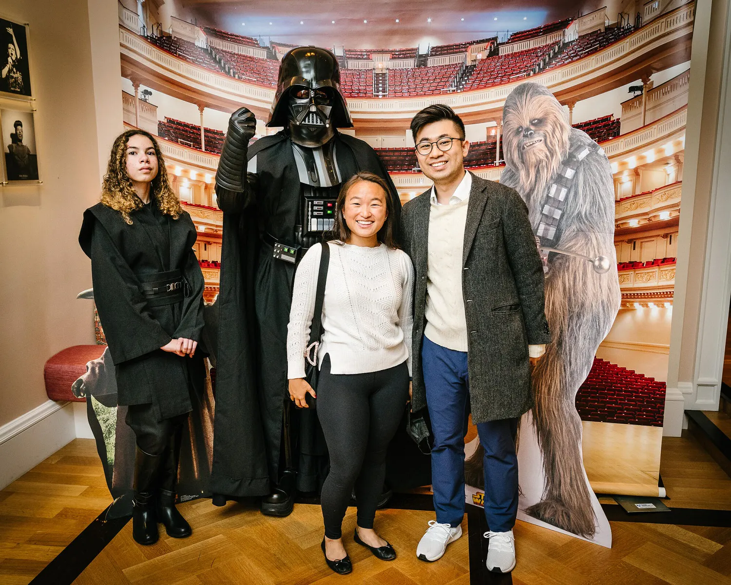 People posing in Star Wars costumes against a backdrop of Carnegie Hall.