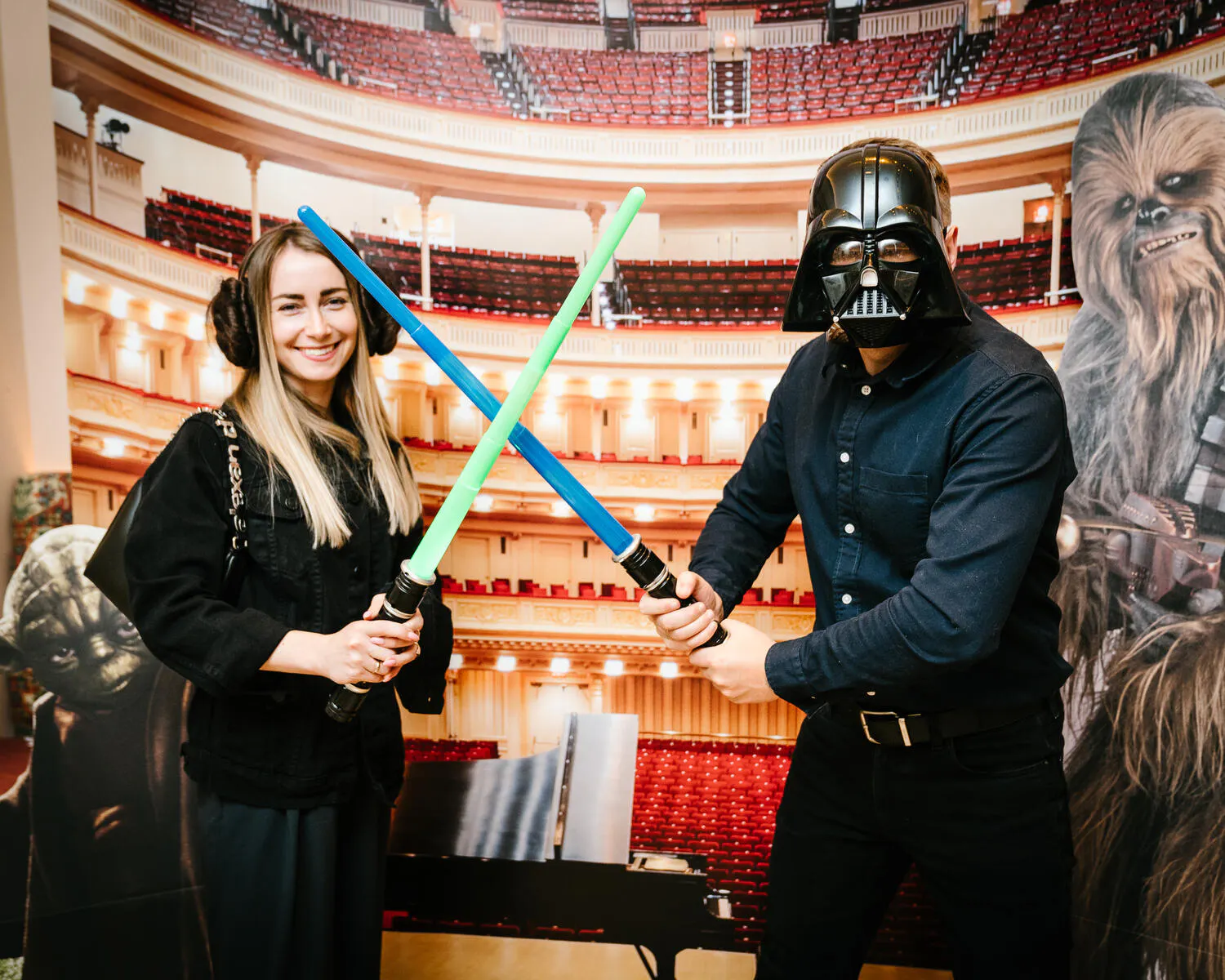 People posing in Star Wars costumes against a backdrop of Carnegie Hall.