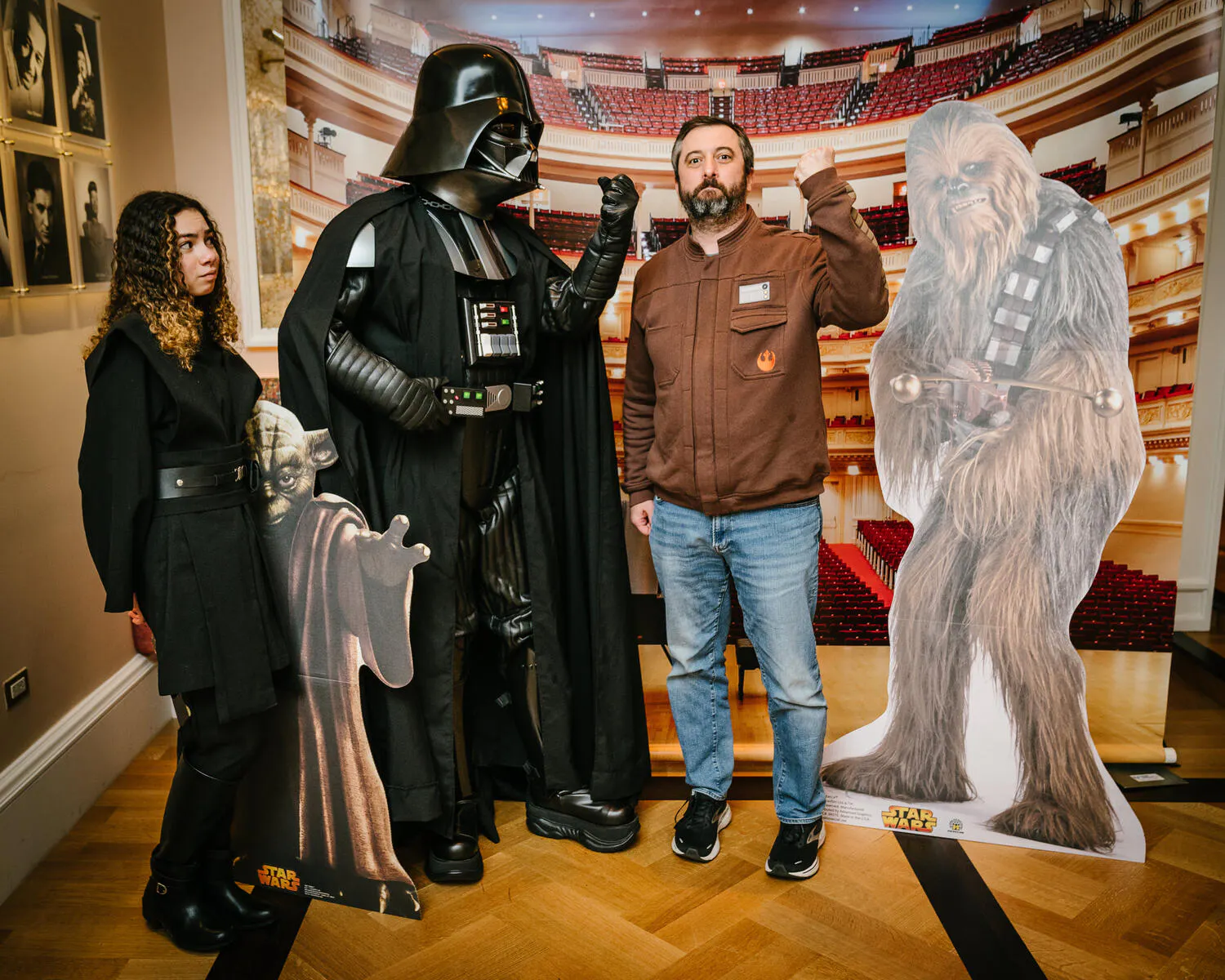 People posing in Star Wars costumes against a backdrop of Carnegie Hall.
