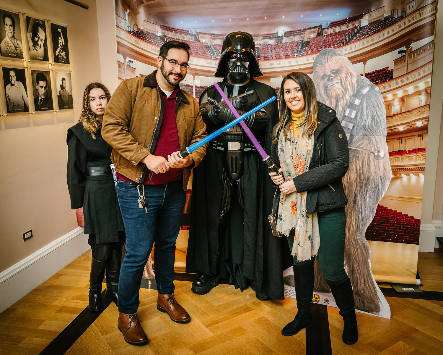 People posing in Star Wars costumes against a backdrop of Carnegie Hall.