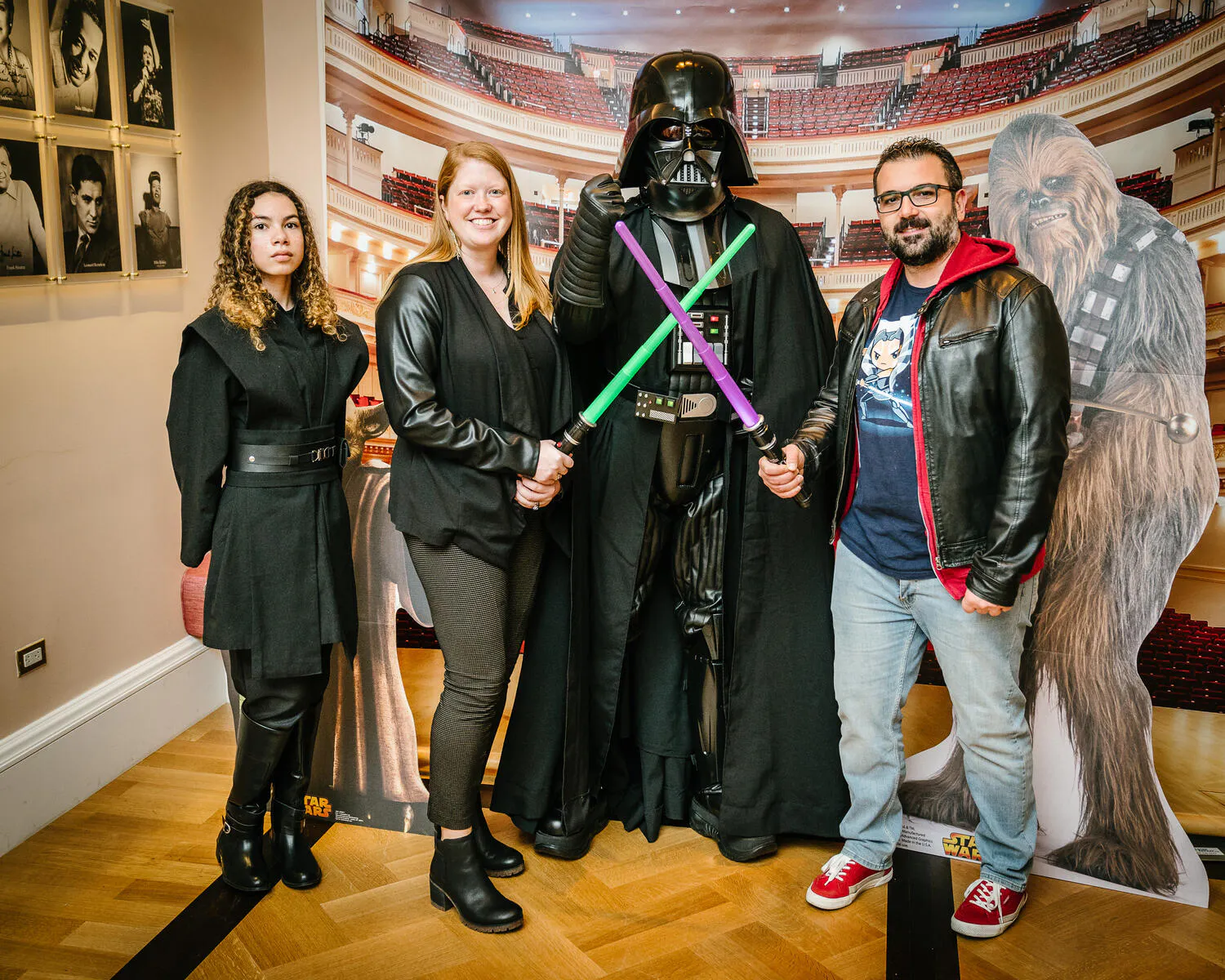 People posing in Star Wars costumes against a backdrop of Carnegie Hall.