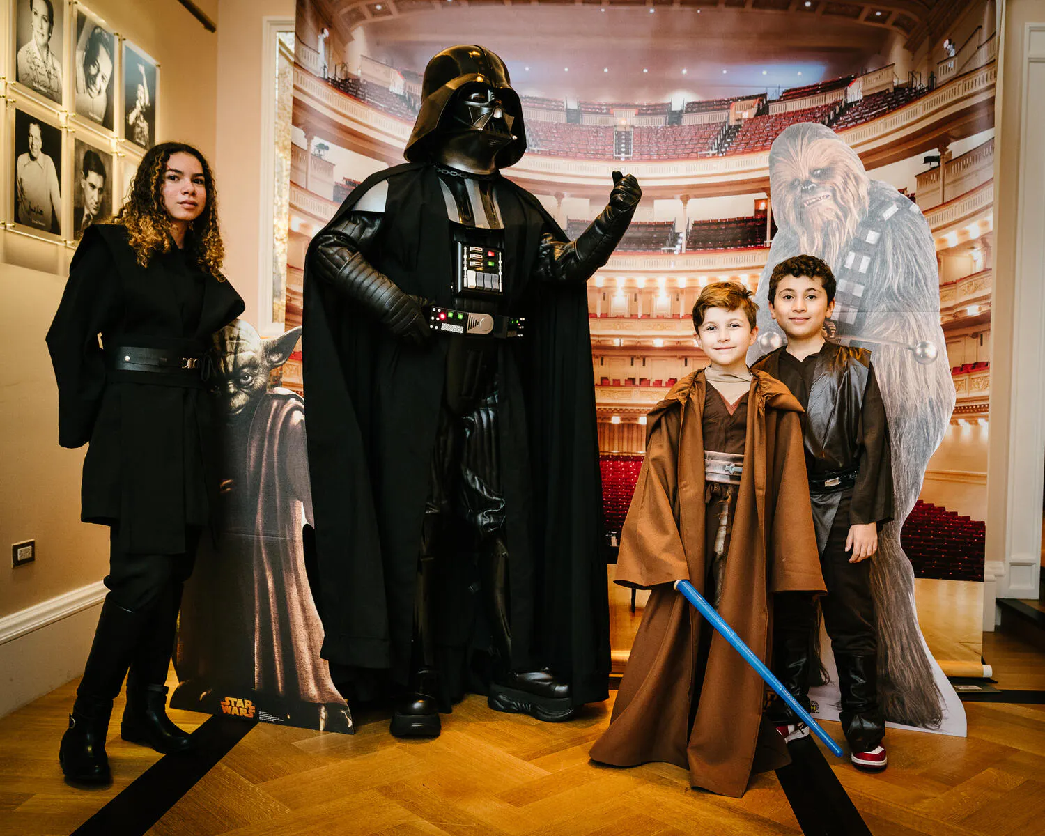 Children posing in Star Wars costumes against a backdrop of Carnegie Hall.