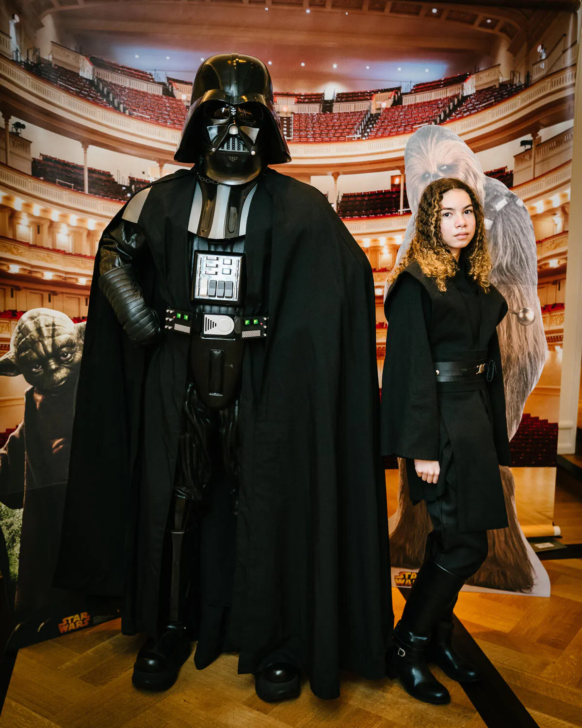 People posing in Star Wars costumes against a backdrop of Carnegie Hall.