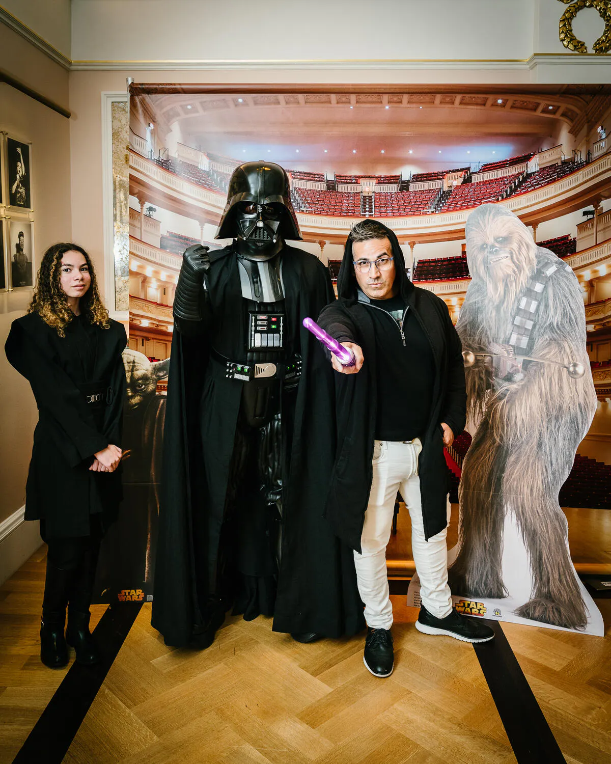 People posing in Star Wars costumes against a backdrop of Carnegie Hall.