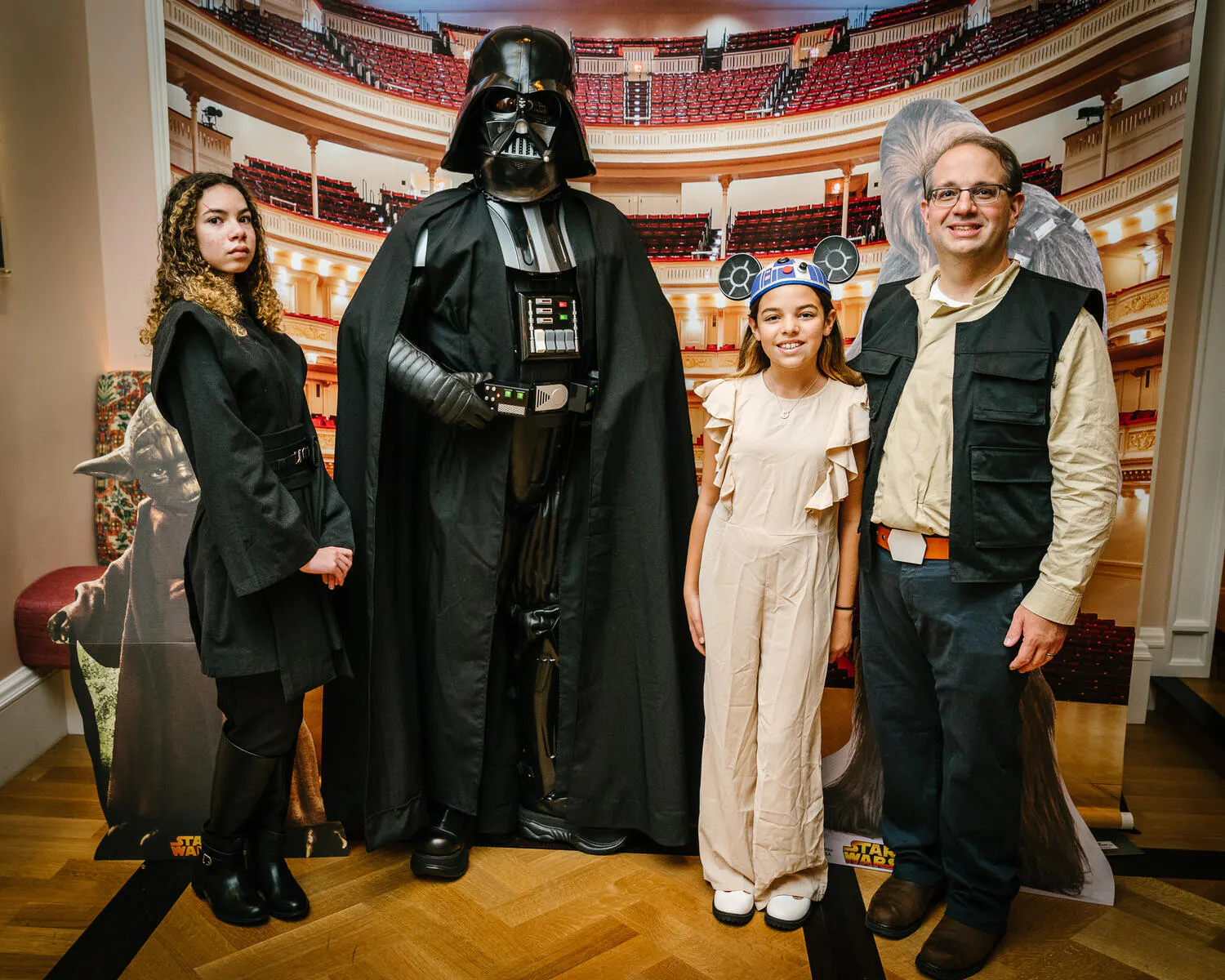 People posing in Star Wars costumes against a backdrop of Carnegie Hall.
