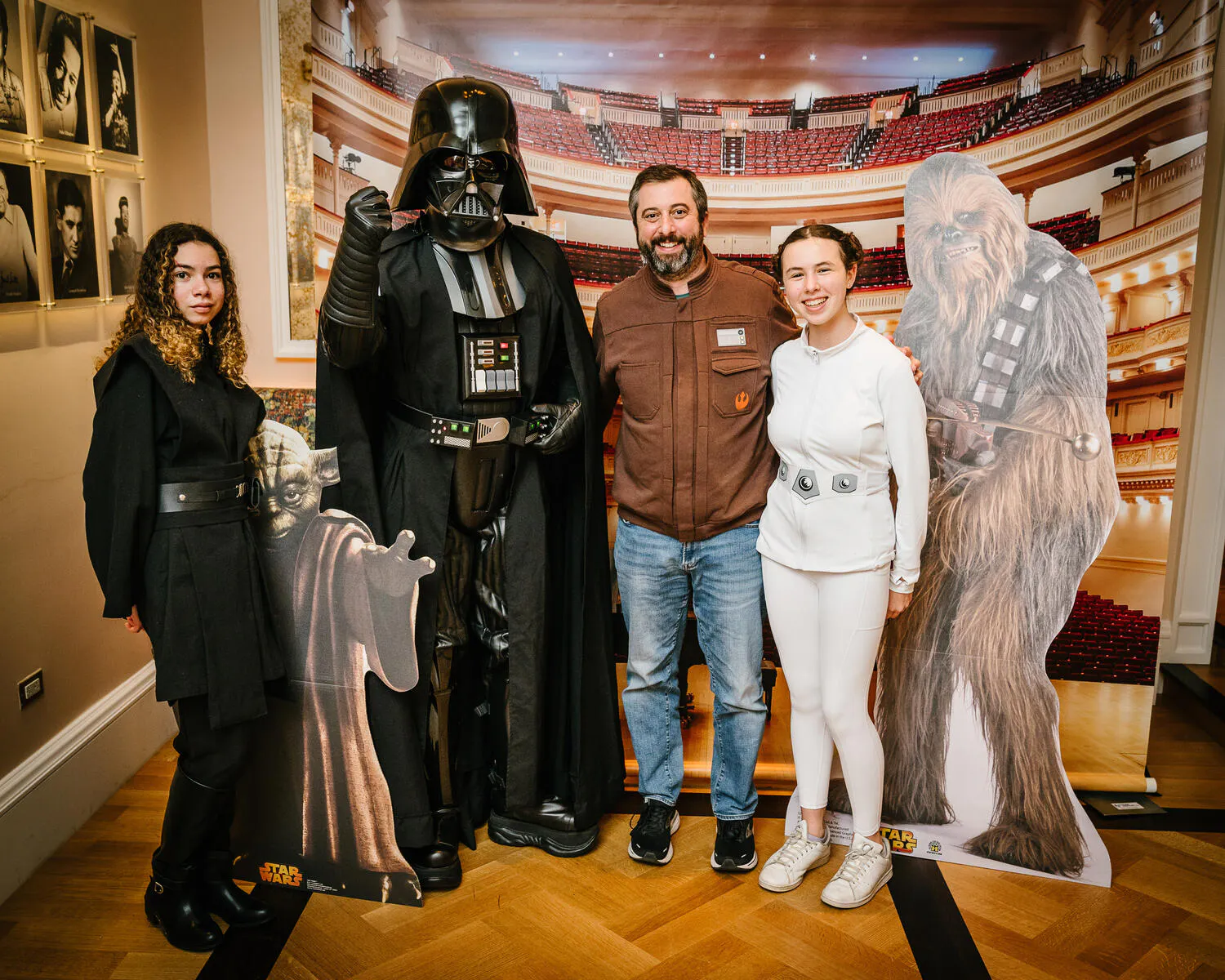 People posing in Star Wars costumes against a backdrop of Carnegie Hall.