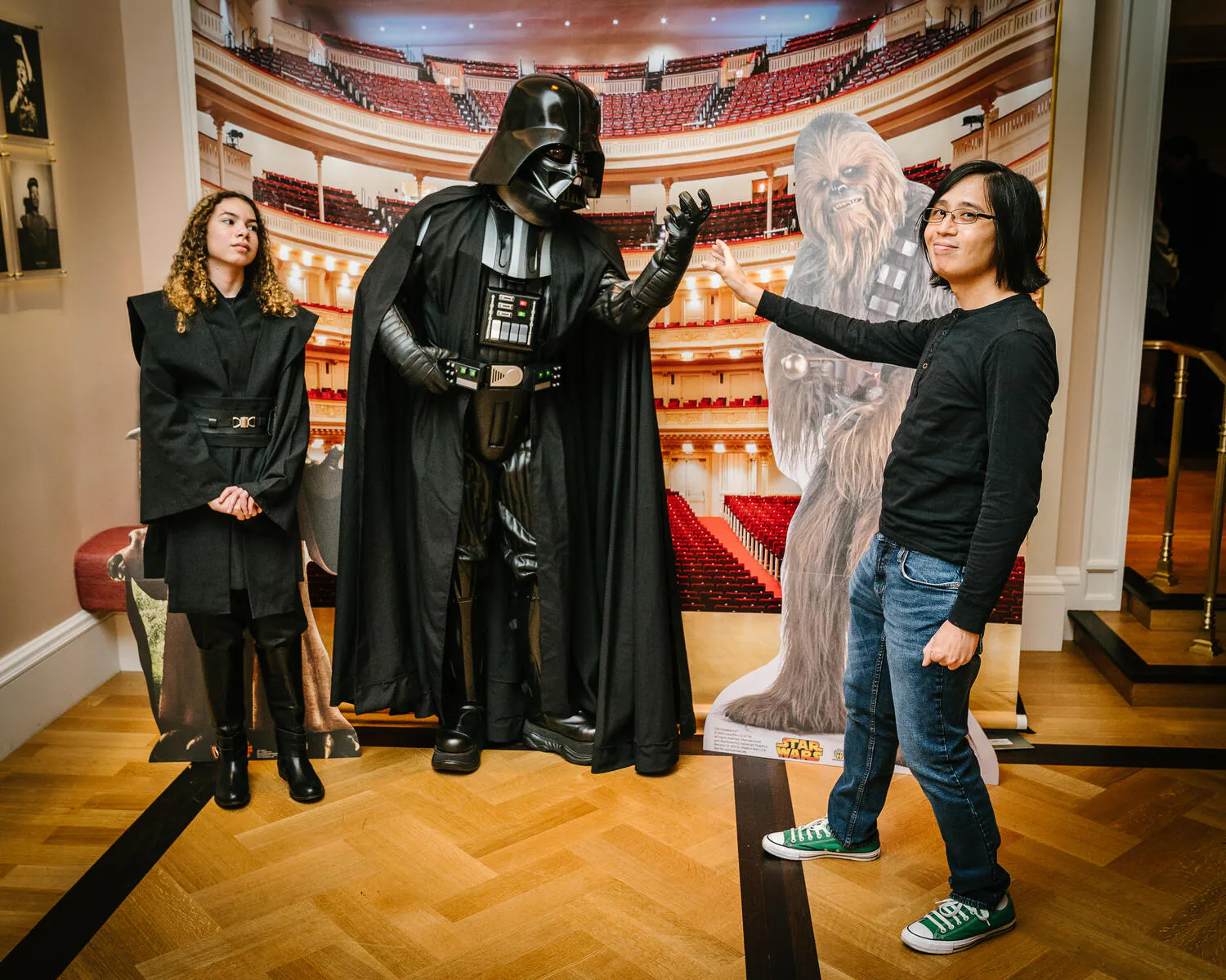 People posing in Star Wars costumes against a backdrop of Carnegie Hall.