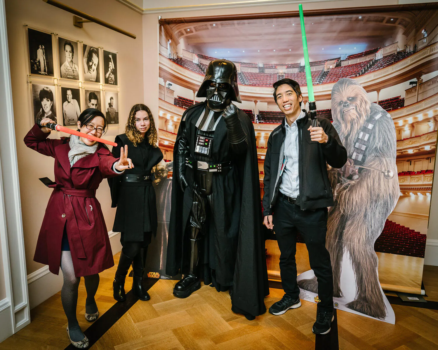 People posing in Star Wars costumes against a backdrop of Carnegie Hall.