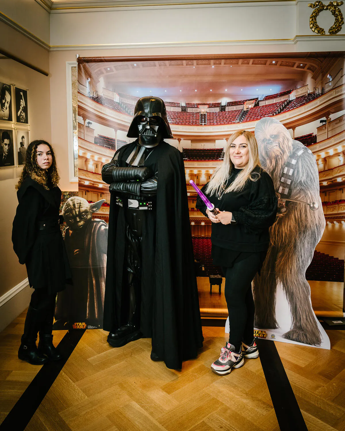 People posing in Star Wars costumes against a backdrop of Carnegie Hall.
