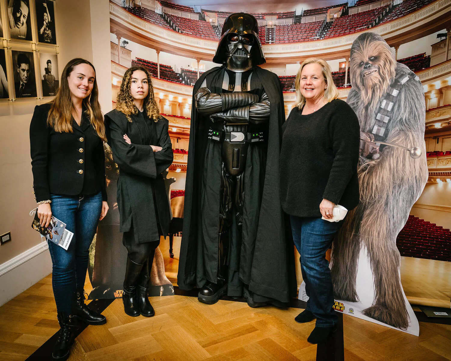 People posing in Star Wars costumes against a backdrop of Carnegie Hall.
