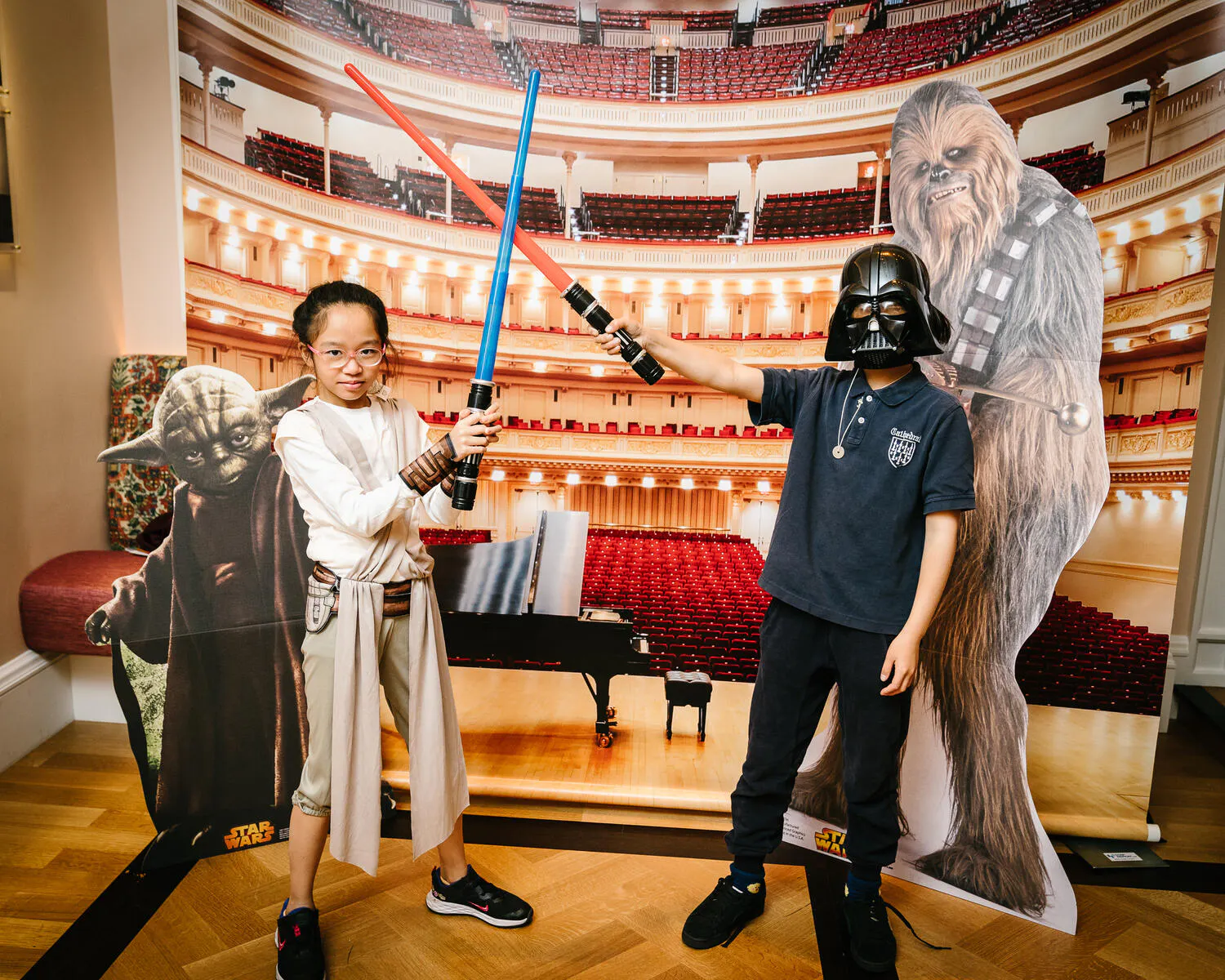 Children posing in Star Wars costumes against a backdrop of Carnegie Hall.