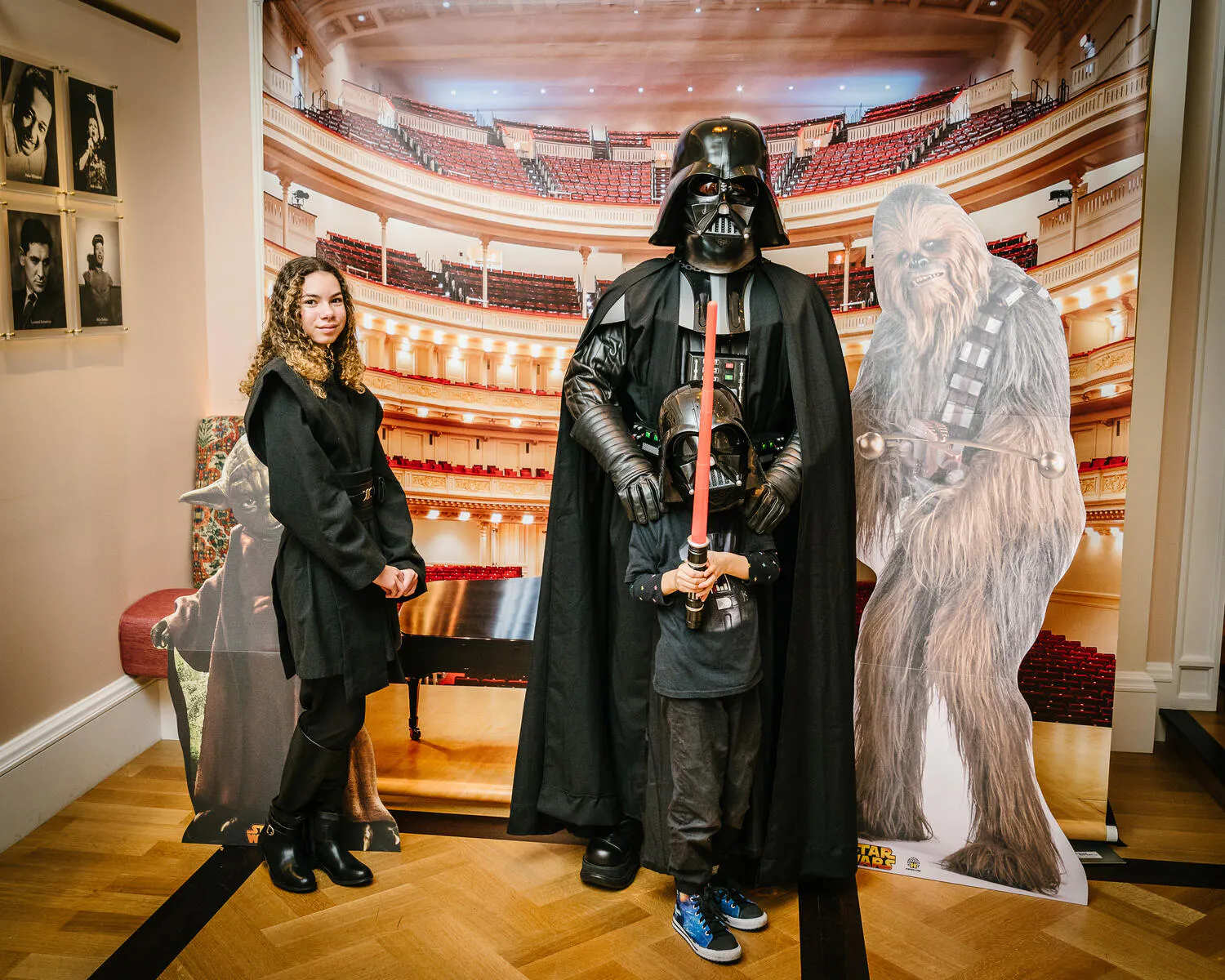 People posing in Star Wars costumes against a backdrop of Carnegie Hall.
