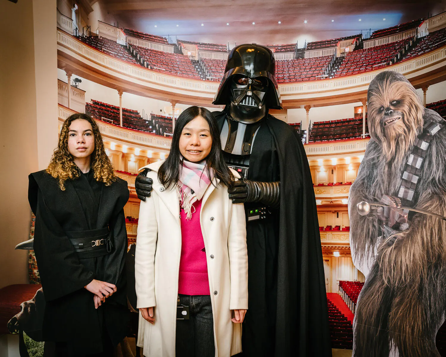 People posing in Star Wars costumes against a backdrop of Carnegie Hall.