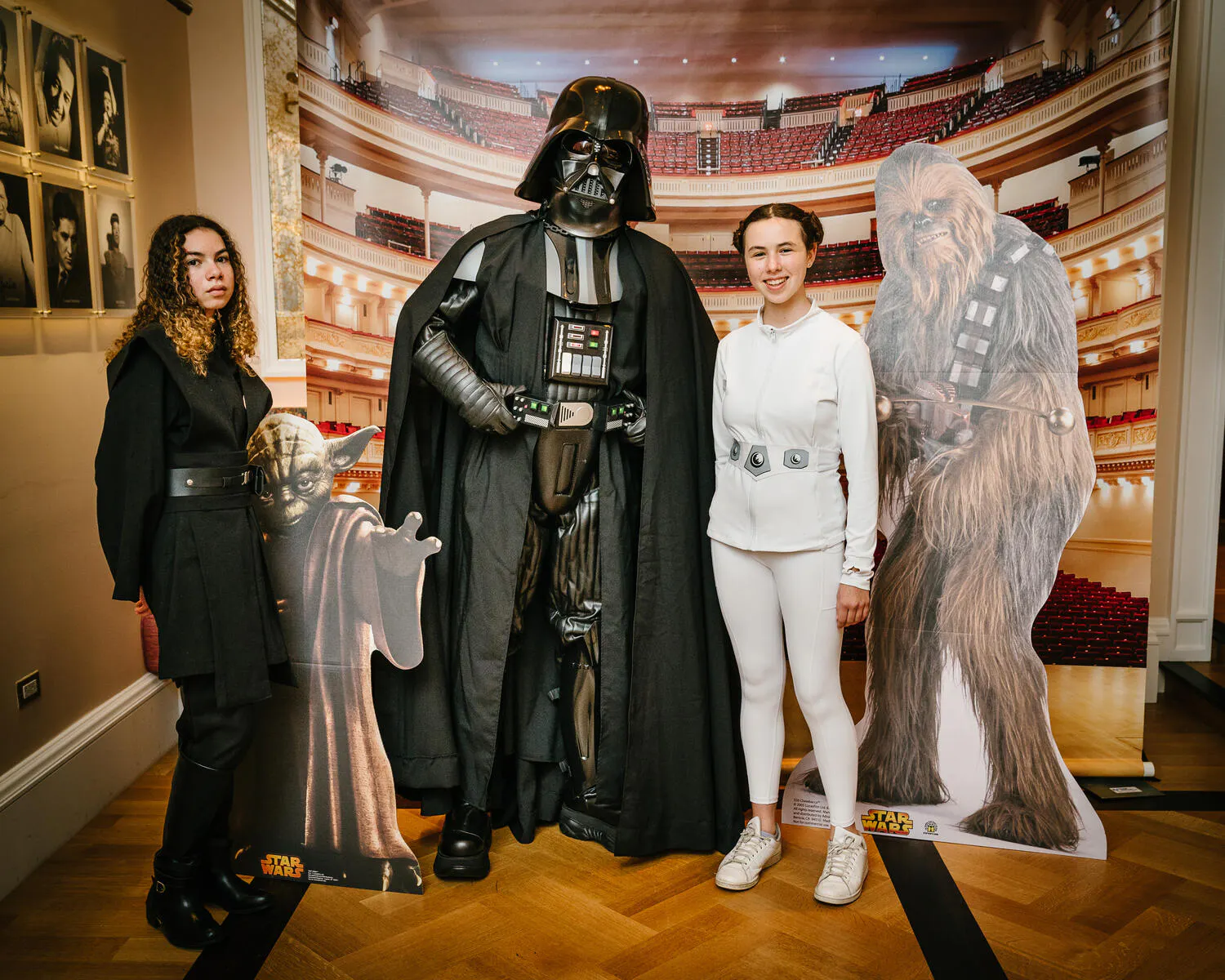 People posing in Star Wars costumes against a backdrop of Carnegie Hall.