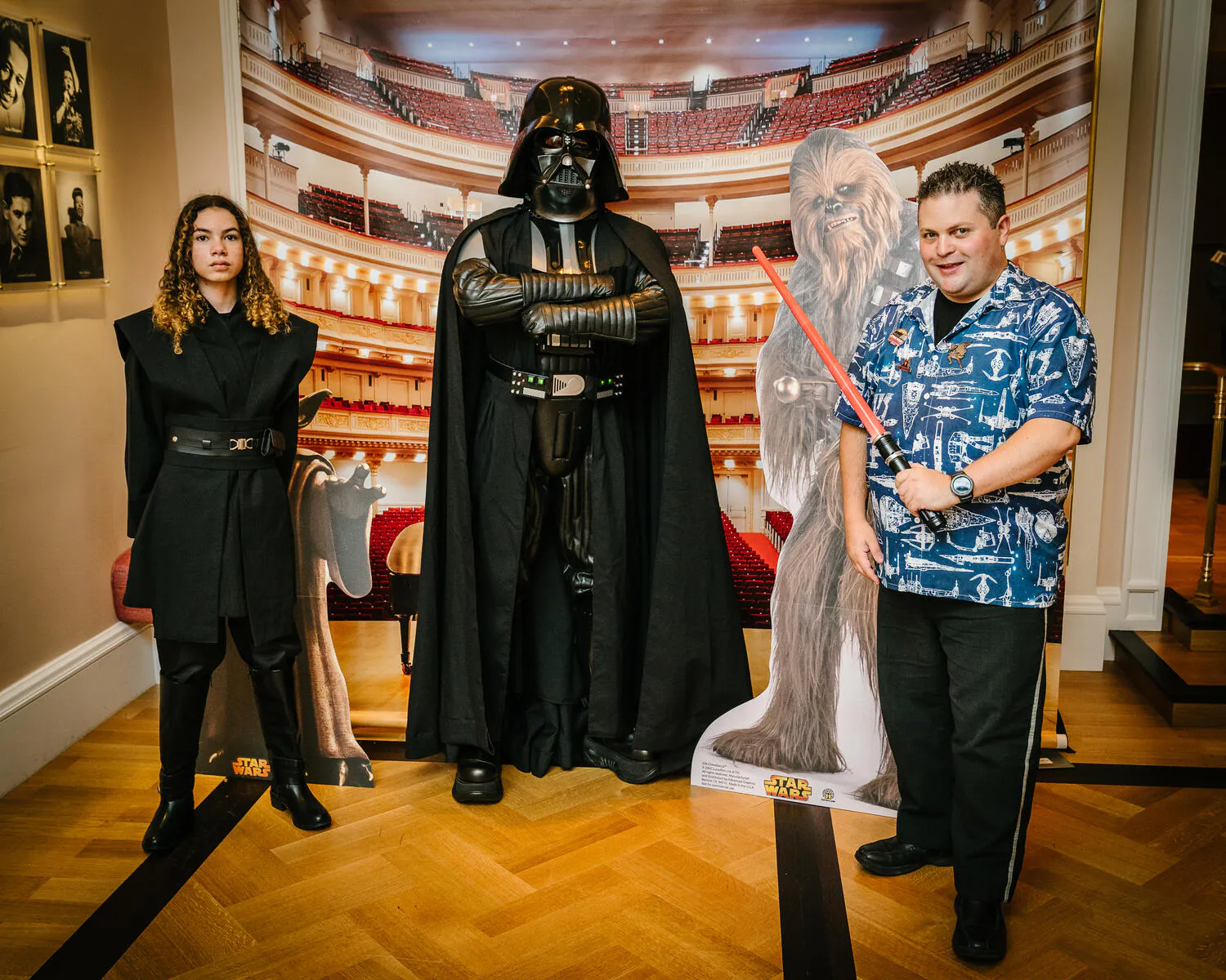 People posing in Star Wars costumes against a backdrop of Carnegie Hall.
