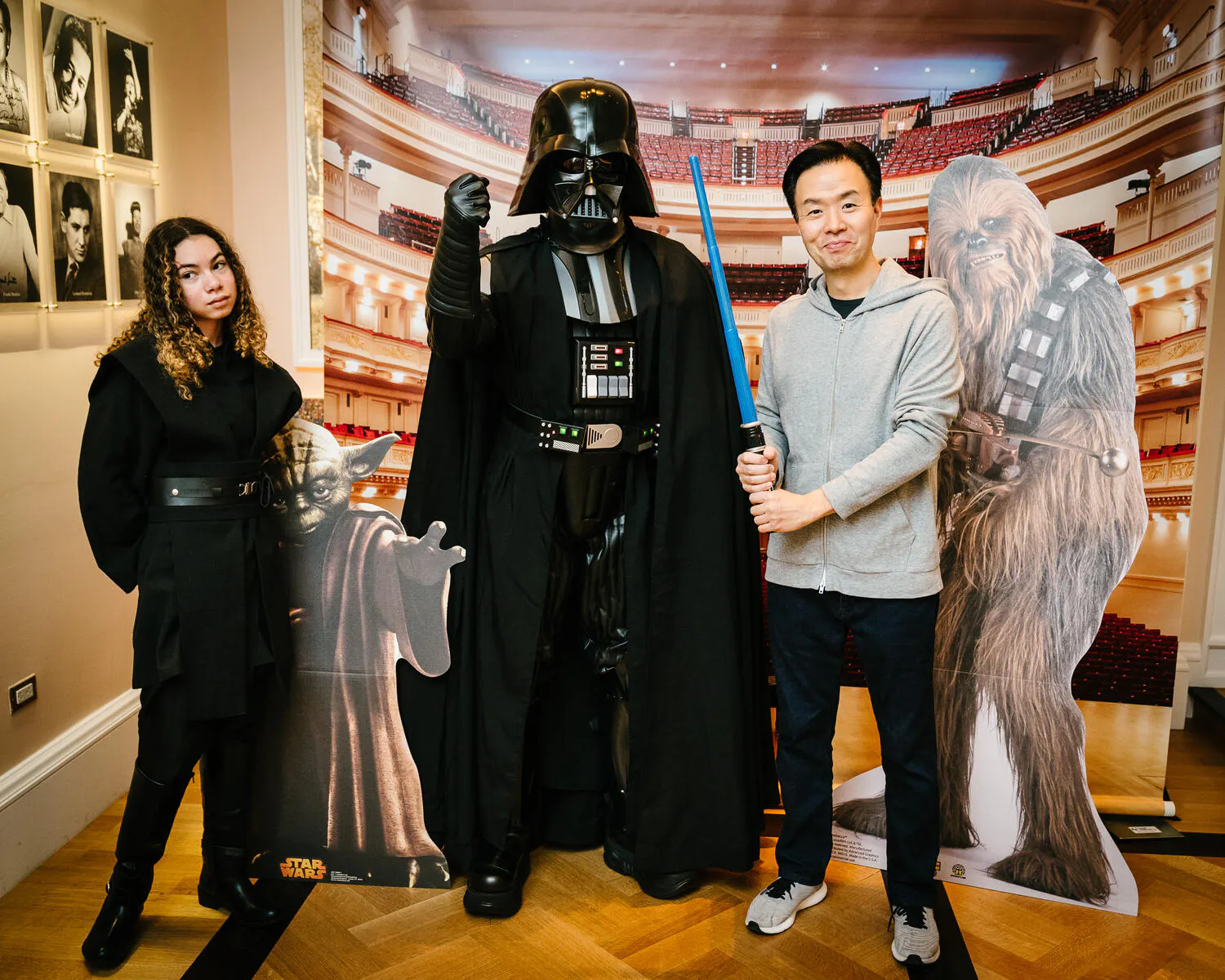People posing in Star Wars costumes against a backdrop of Carnegie Hall.