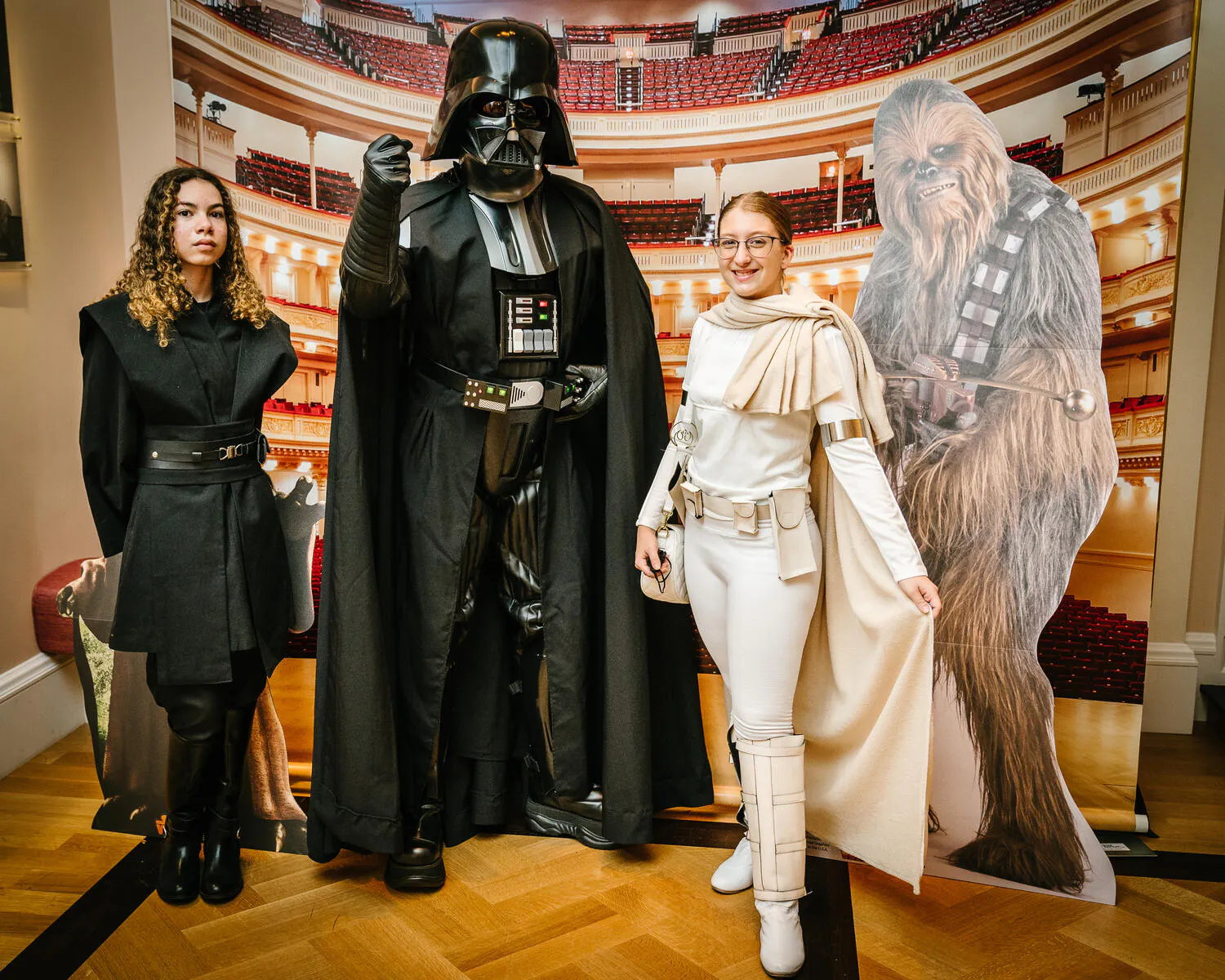 People posing in Star Wars costumes against a backdrop of Carnegie Hall.