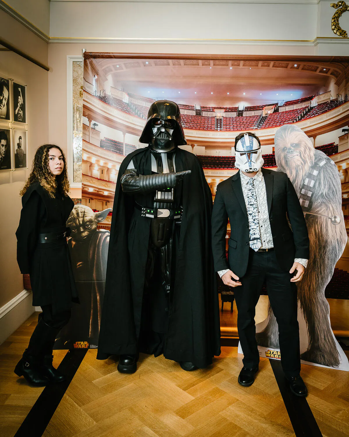 People posing in Star Wars costumes against a backdrop of Carnegie Hall.