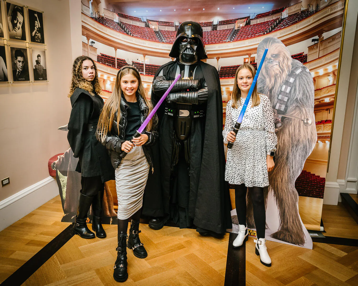 People posing in Star Wars costumes against a backdrop of Carnegie Hall.