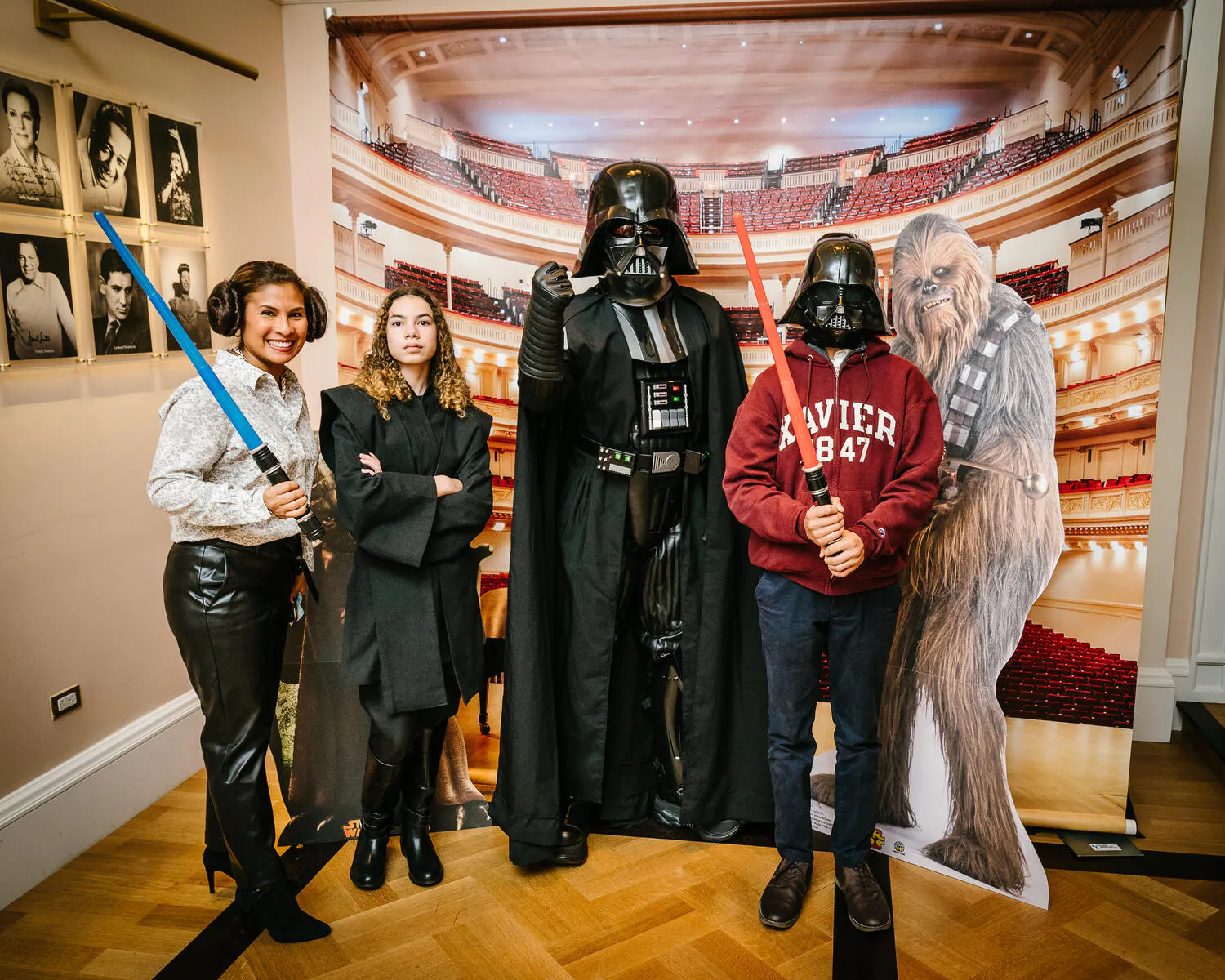 People posing in Star Wars costumes against a backdrop of Carnegie Hall.