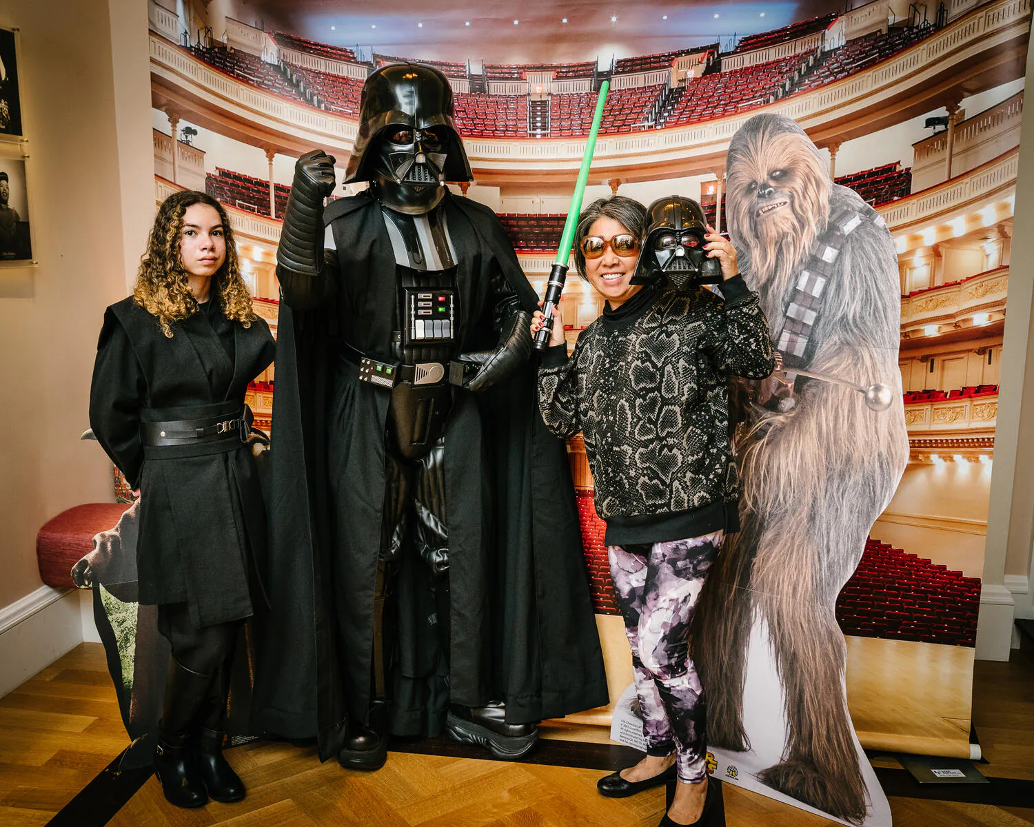 People posing in Star Wars costumes against a backdrop of Carnegie Hall.